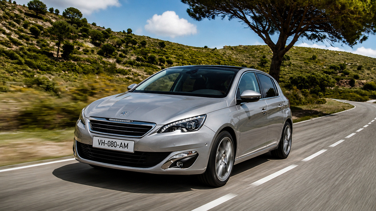 Silver Peugeot hatchback driving on a winding rural road with hills and trees under a partly cloudy sky.