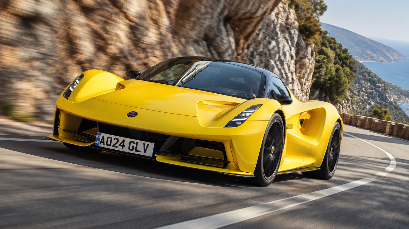 Yellow Lotus Emira sports car driving on a winding coastal road with cliffs and sea in the background.