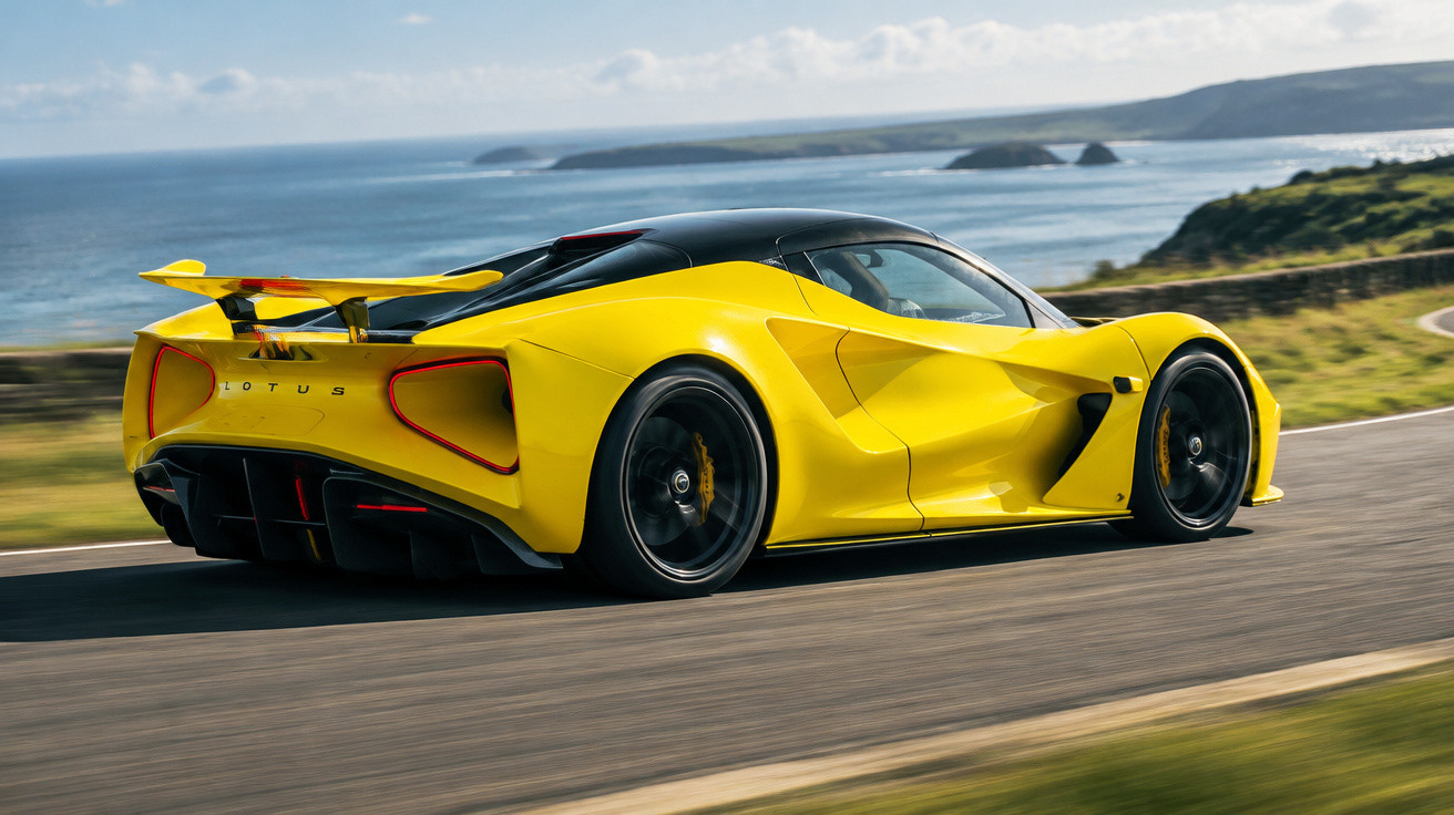 Yellow Lotus sports car driving on a coastal road with ocean and cliffs in the background.